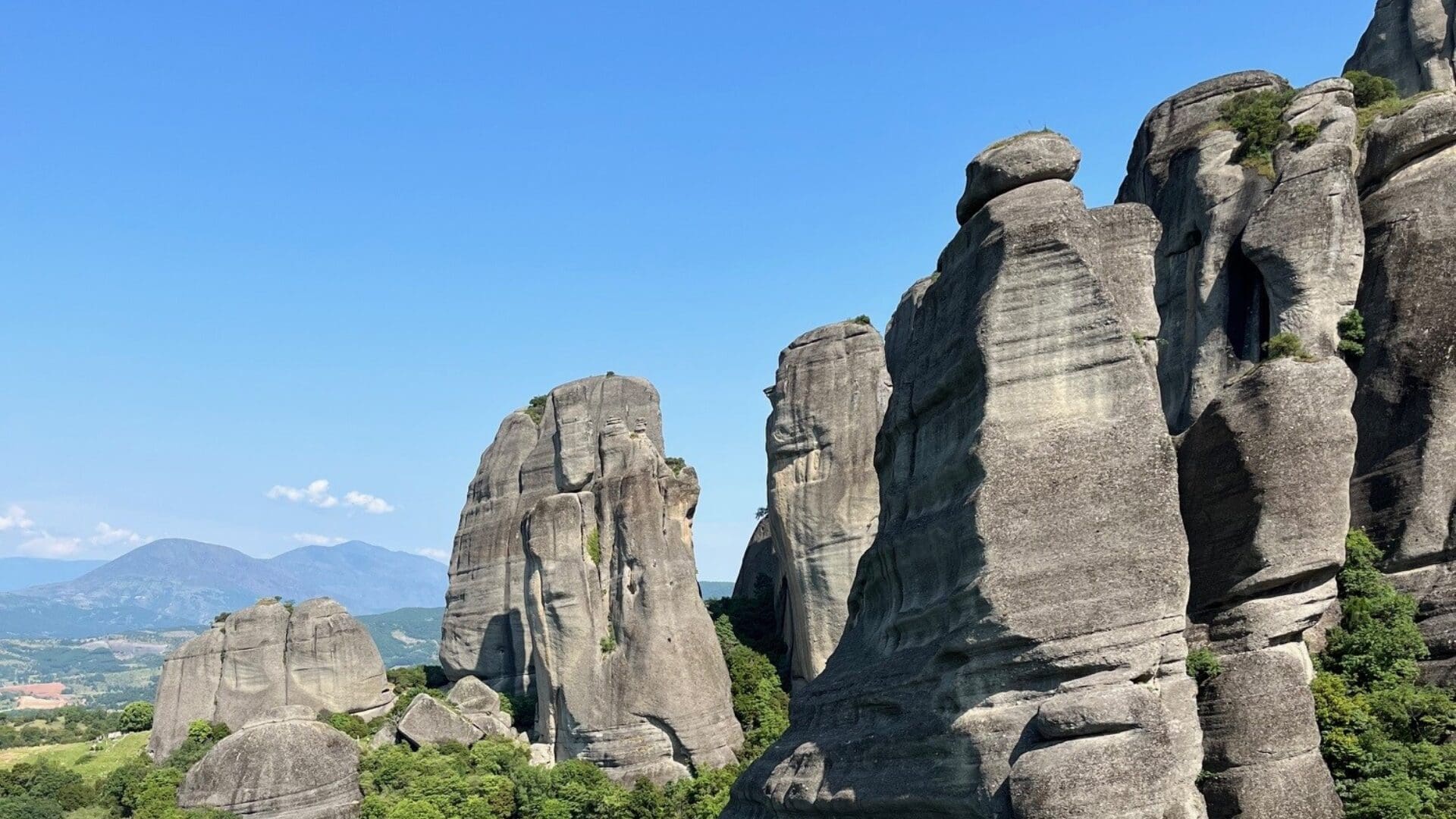Tall rock formations under a clear blue sky.